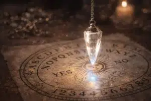 Pendule en cristal suspendu au-dessus d’un cadran divinatoire avec lettres et réponses oui non