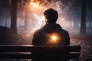 Personne assise sur un banc dans un parc brumeux avec une lumière dans le dos et une silhouette lumineuse près de l’oreille